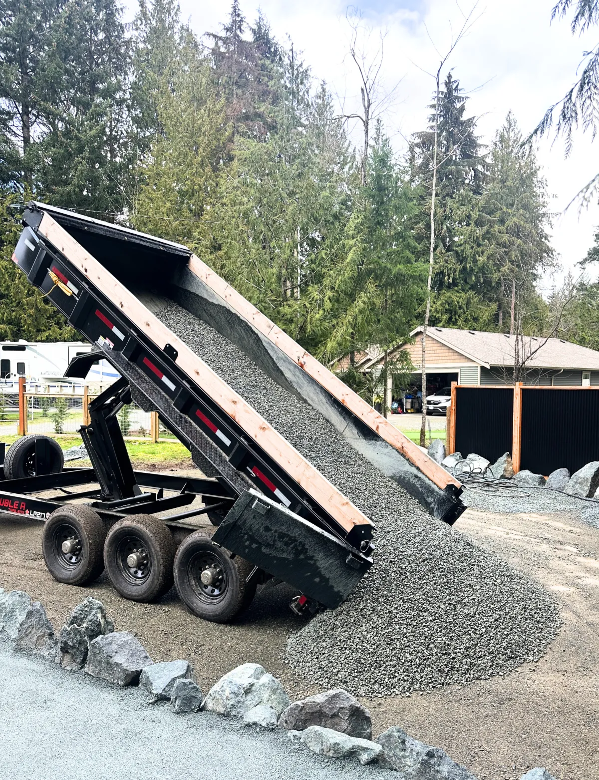 Dump trailer delivering gravel for driveway installation
